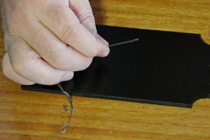 17. Pak beide delen van de lijn tussen je vingers vast en haal de lijn van het pennetje los. Maak nu met het lusje een 8-knoop.